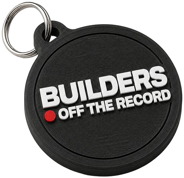 Llavero redondo negro con el logo BUILDERS OFF THE RECORD en blanco y un punto rojo, con su aro metálico